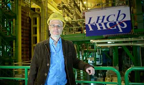 Professor Chris Parkes in hard hat standing on front of industrial equipment