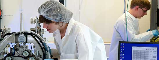 Researchers using equipment in a lab.
