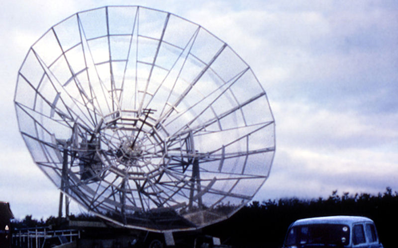 A black and white photograph of a small radio telescope dish.