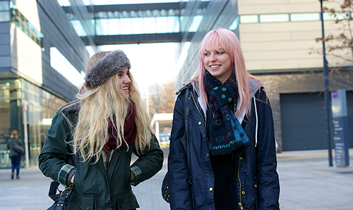 Two female students outside the Alan Turing building