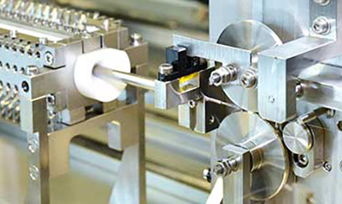 A large silver metal particle detector wiring machine.