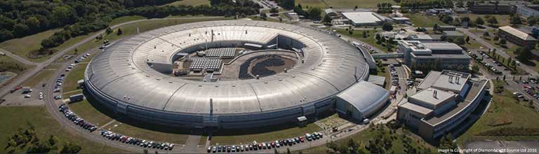 Grey circular building with a large round hole in the middle