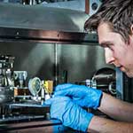 A male student operating accelerator physics equipment
