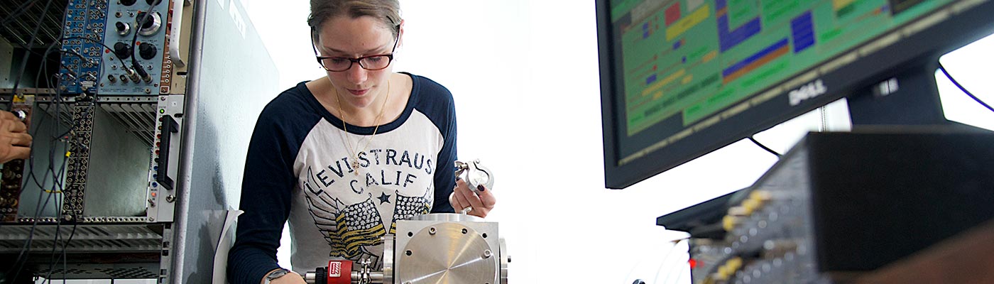 A female student operating equipment in the Nuclear Physics lab